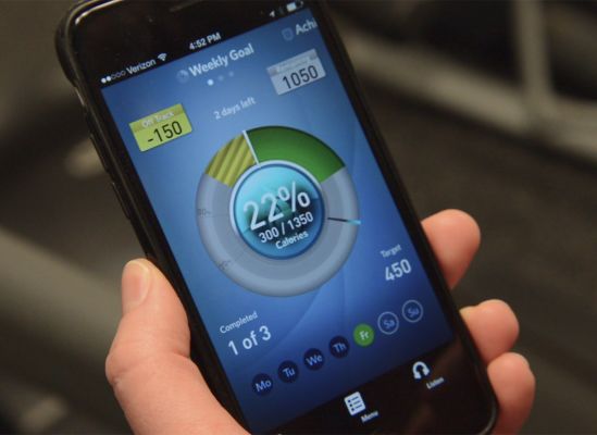 A person looking at a mobile app on their phone that is connected to their treadmill.