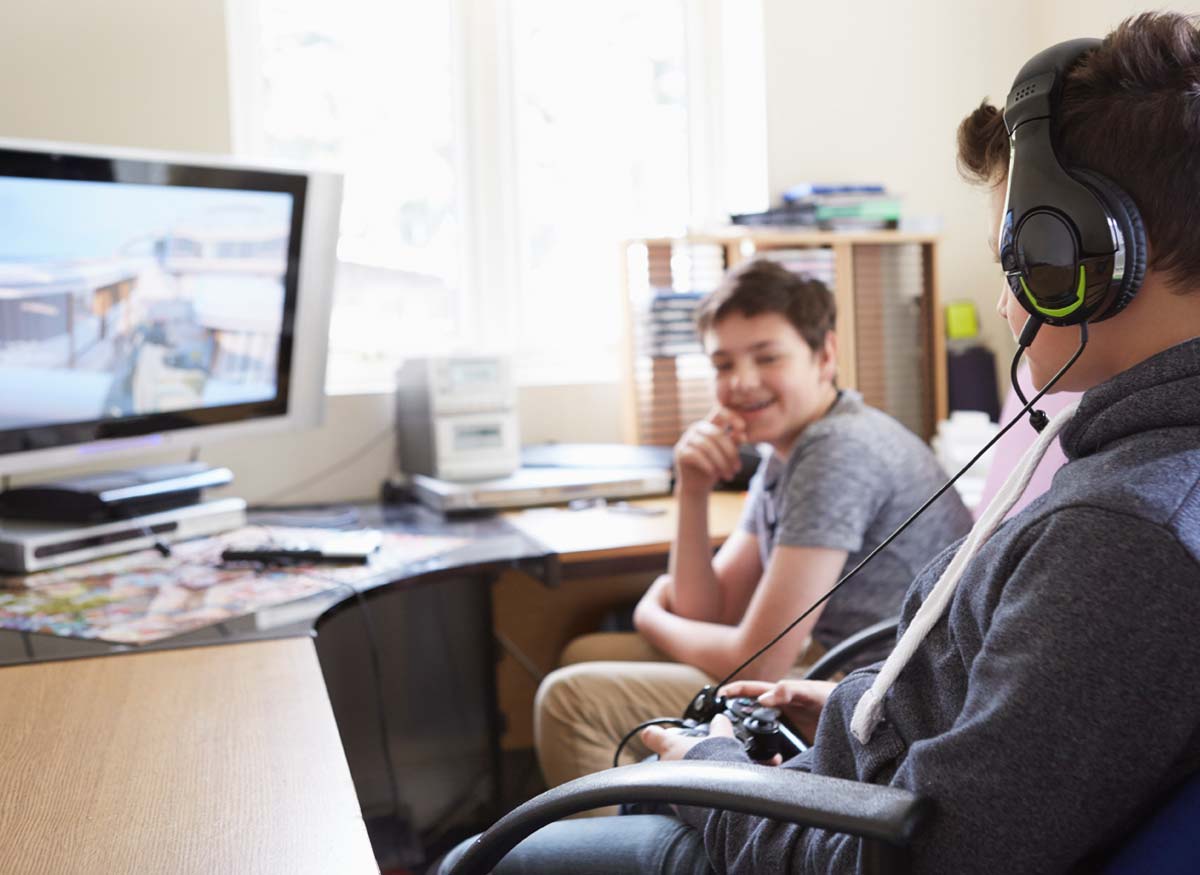 Photo of two kids playing a video game on a computer.