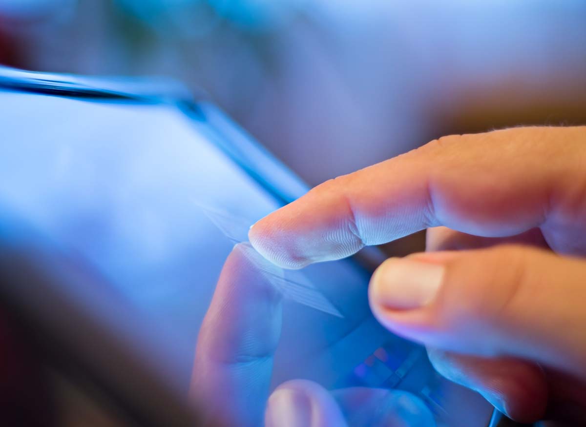 Photo of a person's finger navigating a touchscreen.
