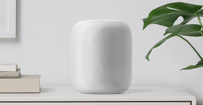 The Apple HomePod speaker sitting on a desk.