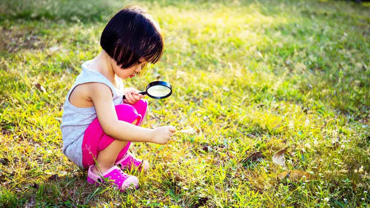 A young child plays in the grass.