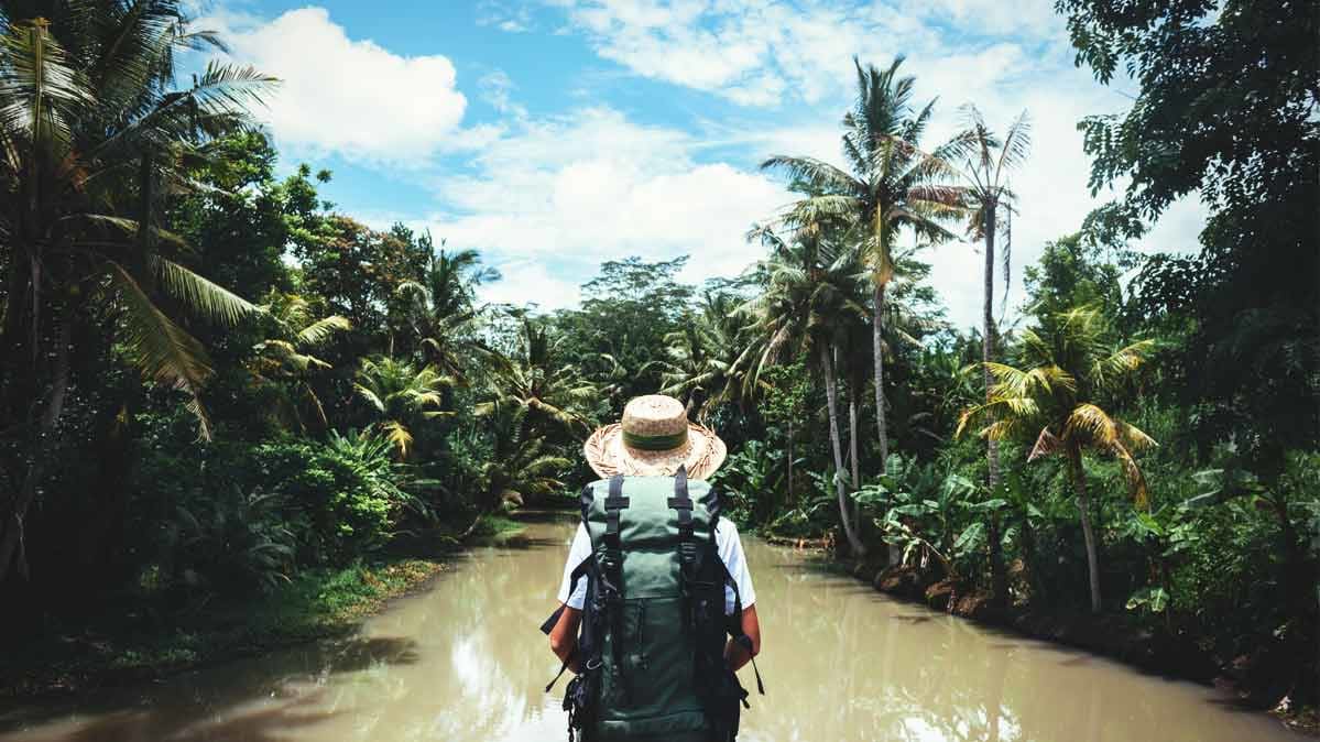 A tourist hiking along a river.