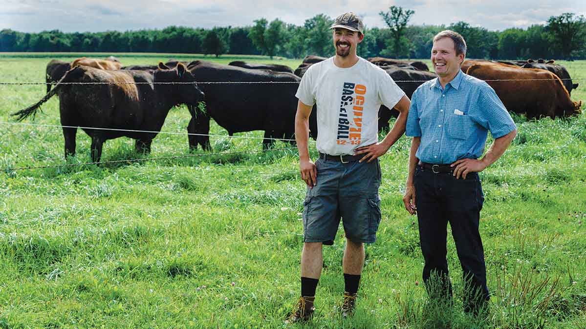 Duane and Tony Munsterteiger standing on the farm in Minnesota. 