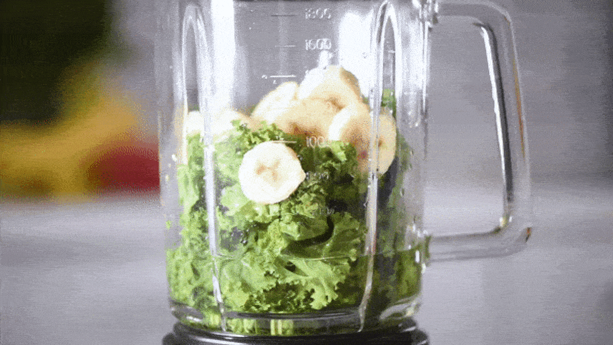 A blender blitzing kale and bananas into a smooth smoothie.