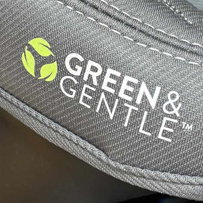 A closeup of car seat material where it says the words "Green & Gentle" with a symbol of three green leaves.