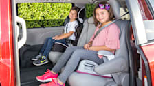 A boy and a girl seated in their booster seats.