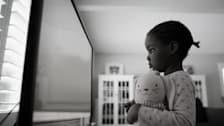 Child standing in front of a large flat screen TV