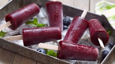 blueberry popsicles in metal tray with ice and blueberries