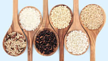 various types of rice on wooden spoons