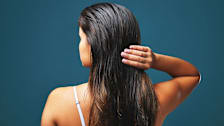 rear view of woman with long hair holding her hair
