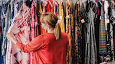woman looking at a rack of dresses