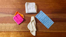 four cloth towels on wooden surface