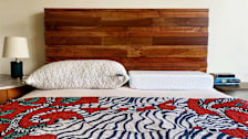 The Coop pillow and the Pillow Cube on a bed with wooden headboard