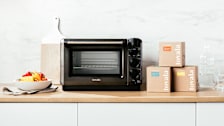black Tovala  oven on kitchen counter with boxes of Tovala meal kits