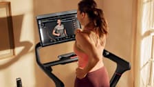 person using Peloton Tread Treadmill with screen showing instructor