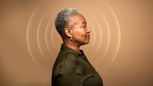 Mature Black woman with sound waves around her head.