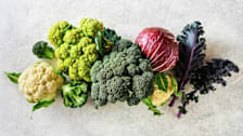overhead view of cauliflower, broccoli, cabbage, and kale