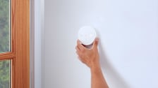 A person placing the Ring broken glass sensor near a glass door
