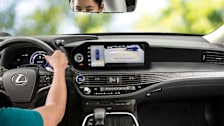 Person in a 2022 Lexus LS 500h with Rear Cross Traffic Alert on the screen
