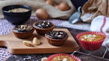 cupcakes with chocolate and brazil nuts on cutting board with eggs in background