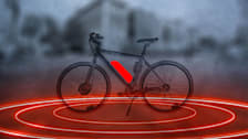 Photo illustration of an e-bike with a bright red battery and red rings emanating from it.