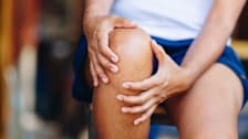 close up of person's hands on knee as though they're in pain