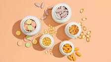 Assortment of vitamins bottles from above with some spilled on surface