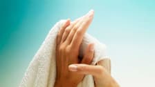 Person drying hand with towel