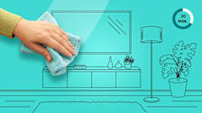 Hand with microfiber cloth in living room setting with teal background