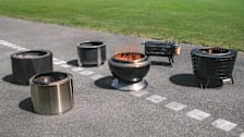 6 different types of smokeless fire pits on asphalt with grass in background