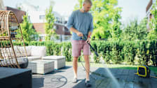 Man cleaning the patio decking with pressure washer