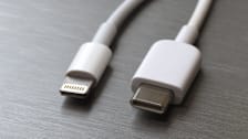 Lightning white cable connector and USB type C on a gray metal background