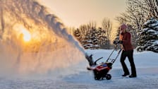 a woman pushing a Toro Power Clear 821 QZE 38757 snow blower through snow