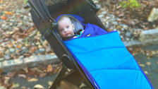 a baby in an L.L.Bean Snow Bunting footmuff on a stroller