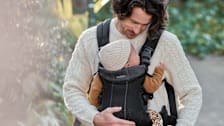 Father holding baby in a baby carrier