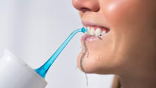 Woman with smile using a portable water flosser