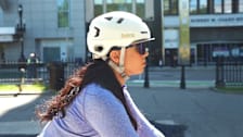 A woman wearing a Bern Hudson Bike Helmet while riding a bike