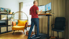 a man working at a standing desk while walking on a treadmill
