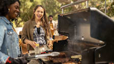 Women cooking at Weber Genesis EPX-335 grill while talking with another woman