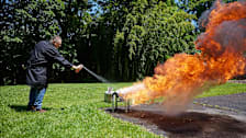 A CR technician attempting to put out a fire with a variety of fire extinguisher.