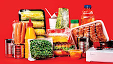 group of various foods (condiments, meats, vegetables, cheeses, etc) in plastic, metal, and paper packaging
