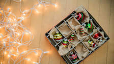 Christmas lights and baubles on wood floor