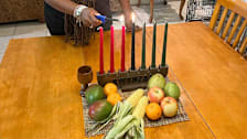 Camille Briggs lighting Kwanzaa candles