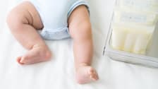 Baby feet next to breastmilk bags