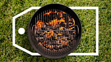 Top-down view of a charcoal grill sitting on grass with a large deals tag surrounding it.