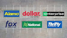 Alamo, Dollar, Enterprise, Fox, National, and Thrifty logos on a parking lot background.