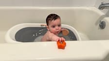 Baby playing with his toys in the OXO Tot Splash n Store Tub