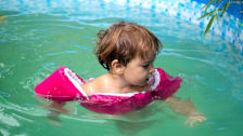 Toddler wearing a Puddle Jumper in a swimming pool.
