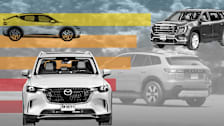 photo illustration of 2026 GMC Acadia, 2026 Mazda CX-90 PHEV, and 2026 Genesis GV60 with graphic horizontal lines and blurred car and trees tinted grey in background
2026 Honda Prologue