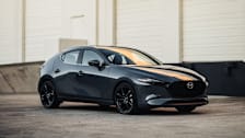 2026 Mazda3 in grey on concrete with white industrial building in background